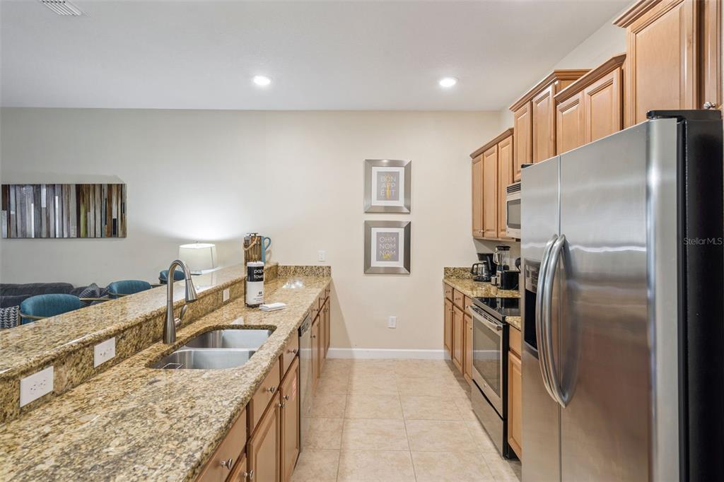 8957 Sugar Palm Road Kissimmee, FL 34747 - Photo 7 of 68 a kitchen with stainless steel appliances granite countertop a sink stove and refrigerator