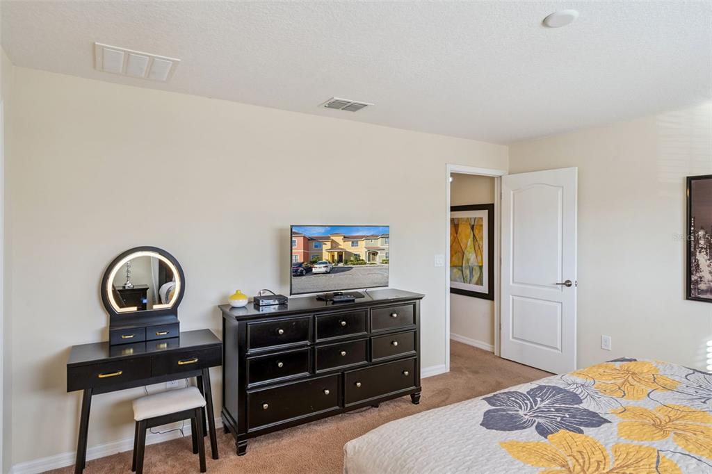 8957 Sugar Palm Road Kissimmee, FL 34747 - Photo 10 of 68 a bedroom with a bed and a dresser