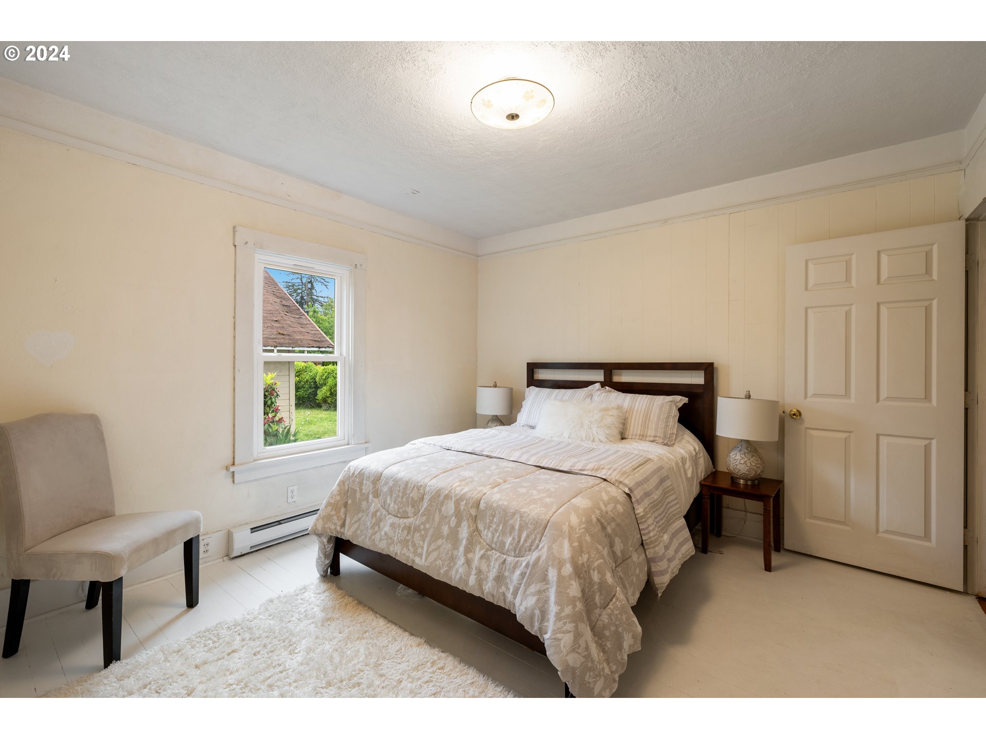 140 Southeast Lamson Street Willamina, OR 97396 - Photo 13 of 46 a bedroom with a bed and a chair