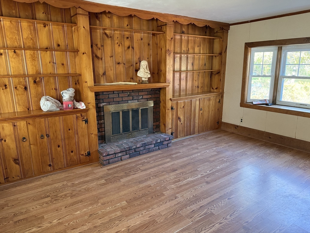 100 Poplar Street Danvers, MA 01923 - Photo 2 of 24 an empty room with wooden floor fireplace and windows