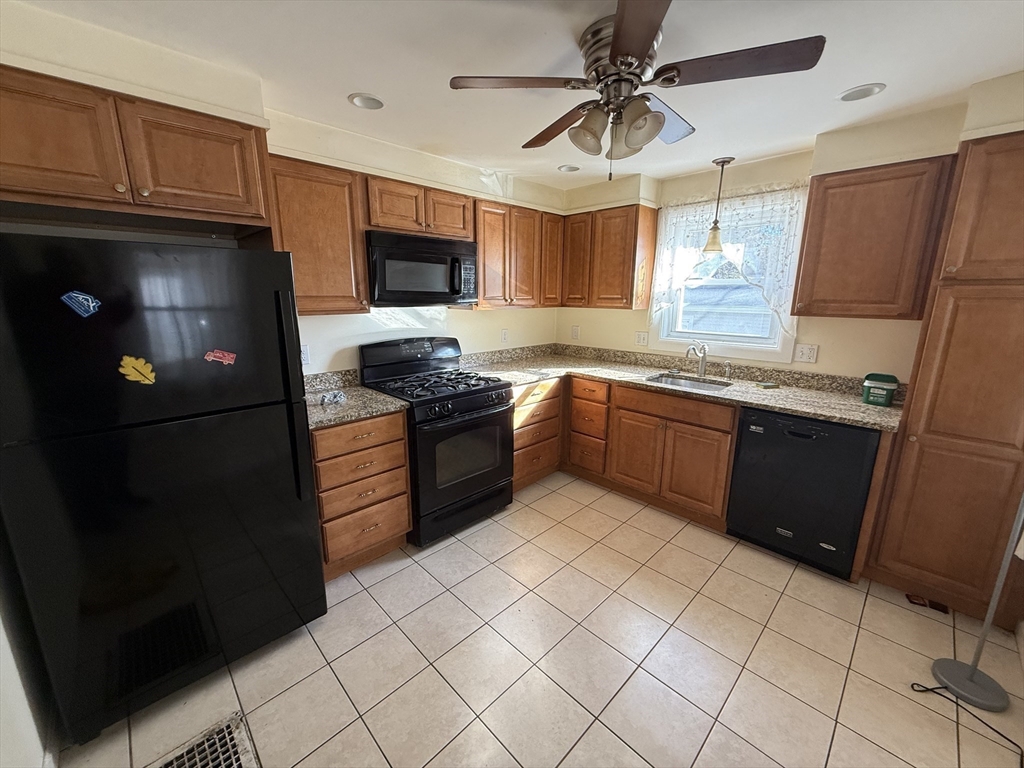 100 Poplar Street Danvers, MA 01923 - Photo 5 of 24 a kitchen with stainless steel appliances granite countertop a refrigerator a stove a sink and a microwave