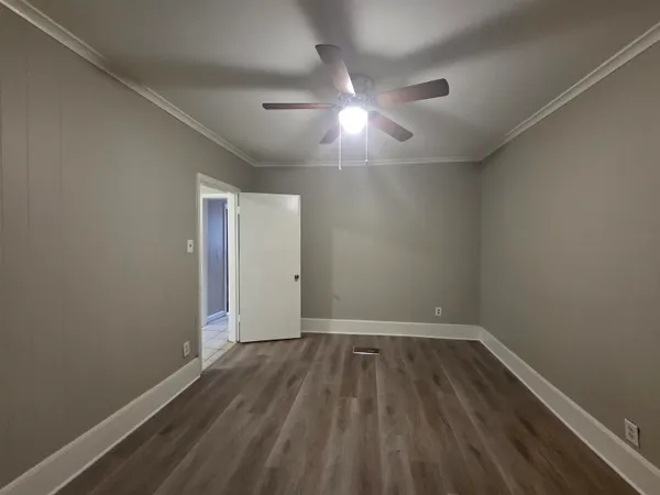 a view of an empty room with wooden floor