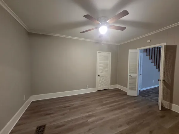 a view of an empty room with wooden floor fireplace and a window