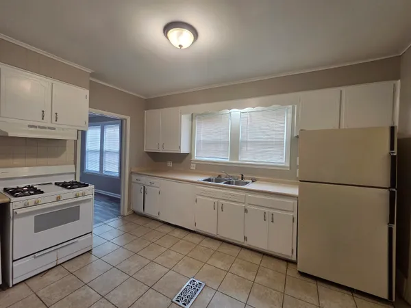 a kitchen with white cabinets and white appliances