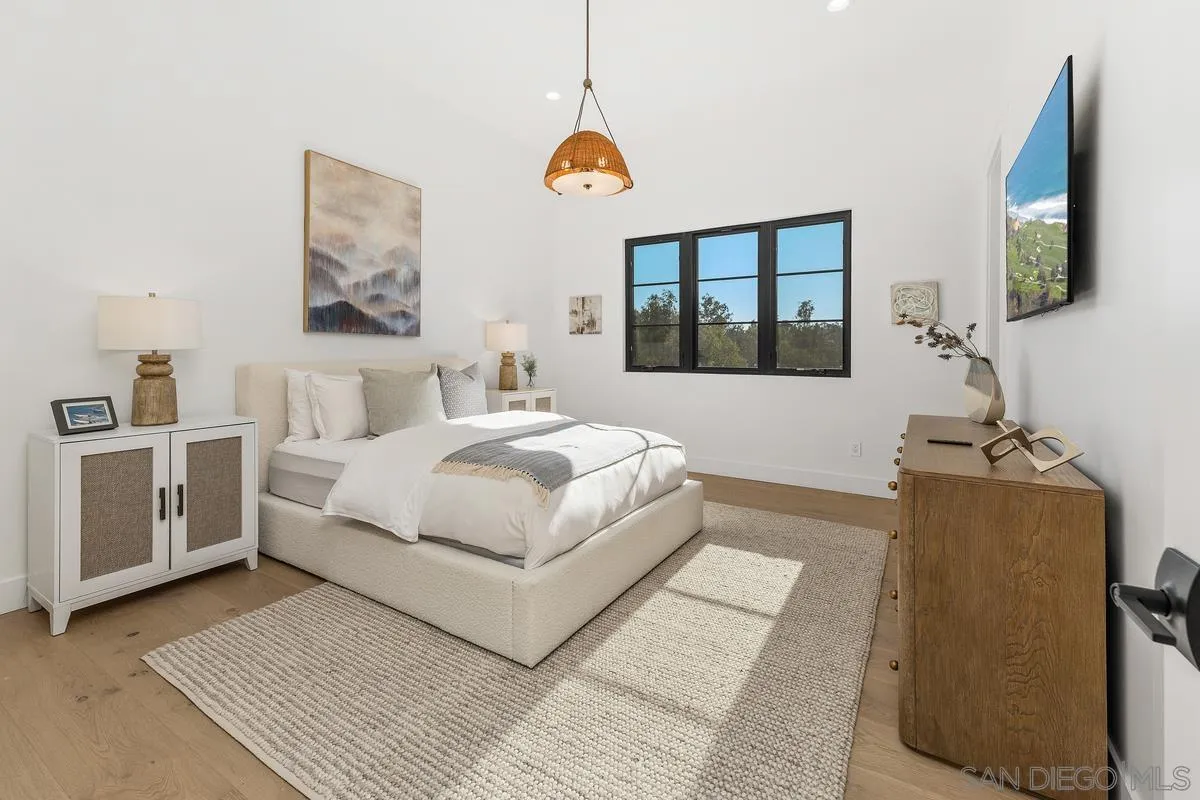 6691-93 Camino Saucito Rancho Santa Fe, CA 92067 - Photo 44 of 55 a bedroom with a bed a couch and a flat tv screen on dresser