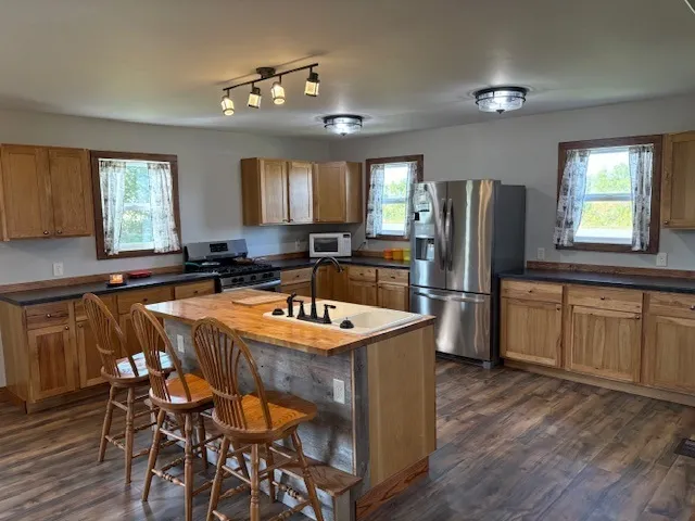 a kitchen with granite countertop a sink appliances a window and dining table
