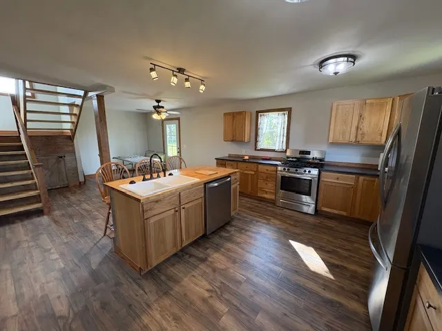 a kitchen with stainless steel appliances granite countertop a sink a stove and a refrigerator