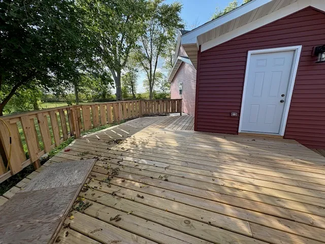 a view of backyard with wooden fence and large trees