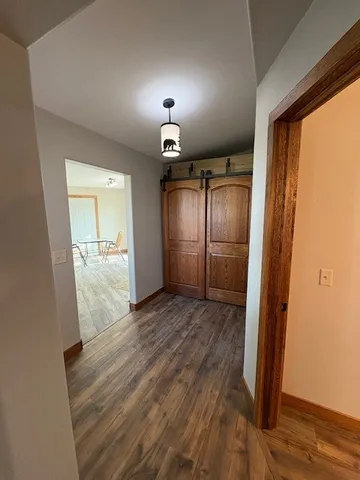 an empty room with wooden floor cabinet and front door