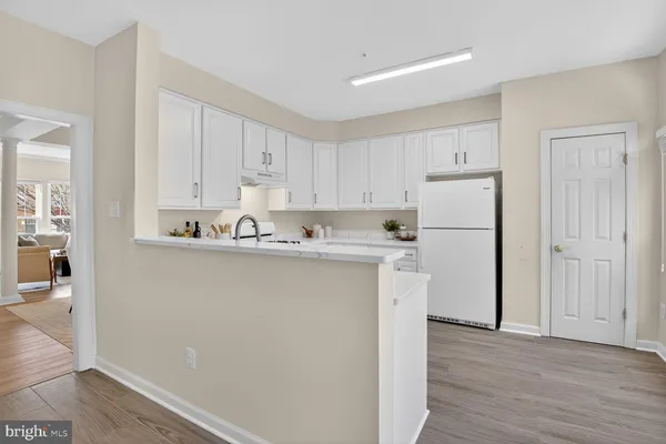 a view of kitchen with refrigerator sink and cabinets