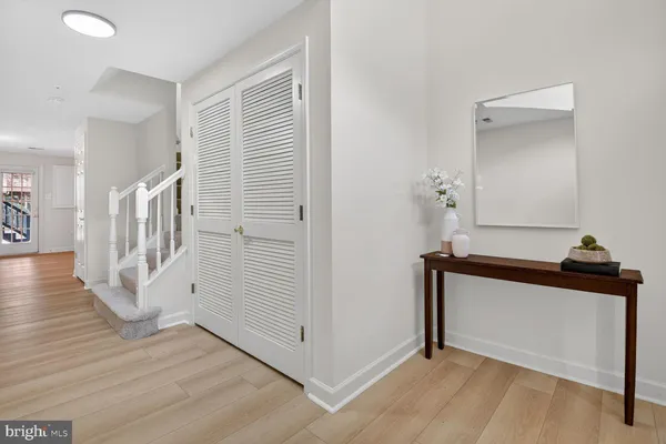 a view of a hallway with entryway and wooden floor