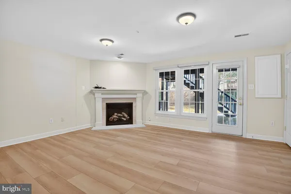 a view of an empty room with a fireplace and a window