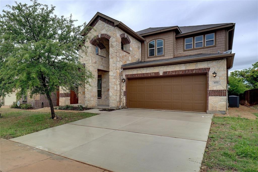 a front view of a house with a garden and trees