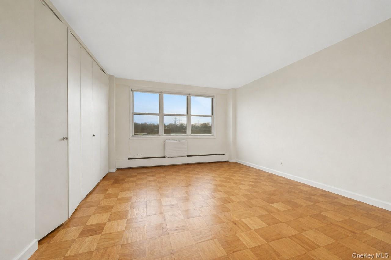 615 Palmer Road, Unit 1004 Yonkers, NY 10701 - Photo 15 of 21 Opposite view of bedroom showing wall to wall windows, wall AC unit, and ample storage space.