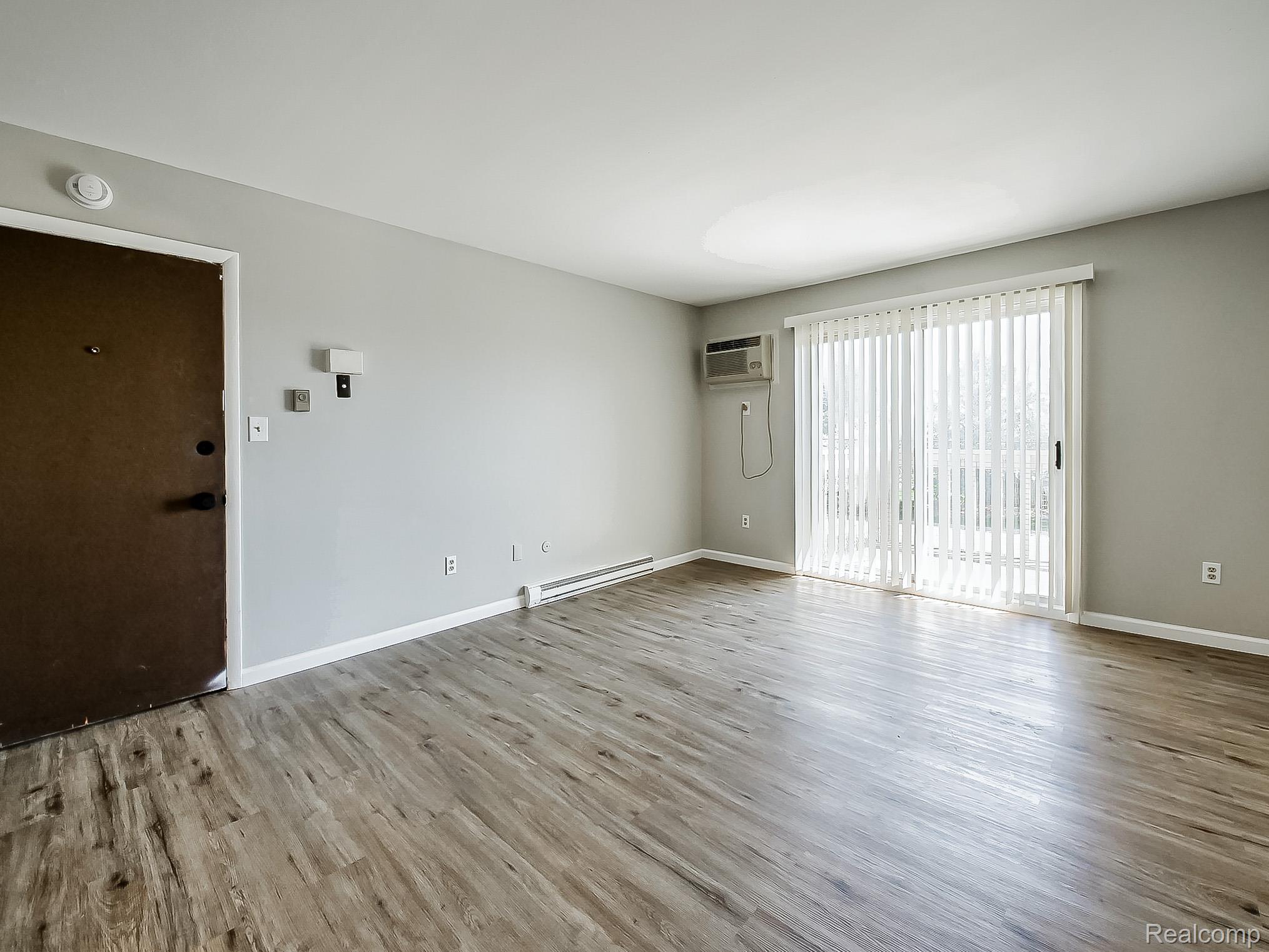 125 East Van Riper Road, Unit 5 Fowlerville, MI 48836 - Photo 2 of 23 Spare room featuring baseboard heating and light wood-type flooring