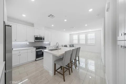 a large kitchen with kitchen island a sink table and chairs