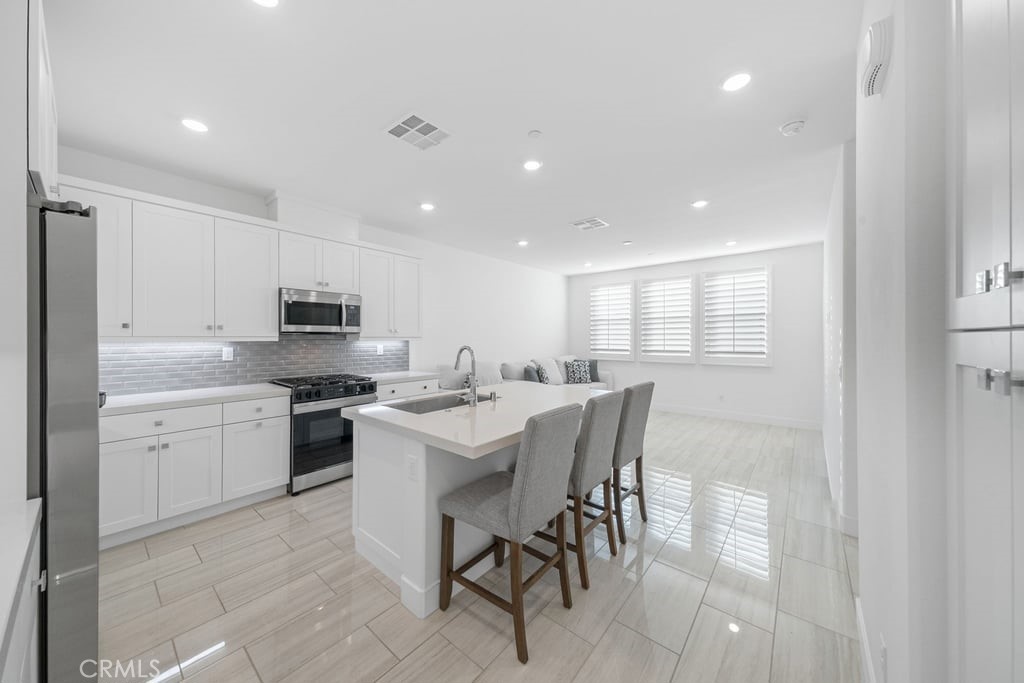 3040 Cove Street Rancho Mission Viejo, CA 92694 - Photo 4 of 44 a large kitchen with kitchen island a sink table and chairs