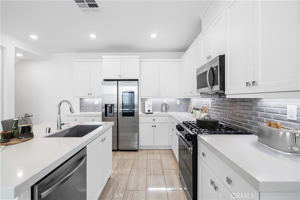 3040 Cove Street Rancho Mission Viejo, CA 92694 - Photo 6 of 44 a kitchen with a sink a stove and refrigerator