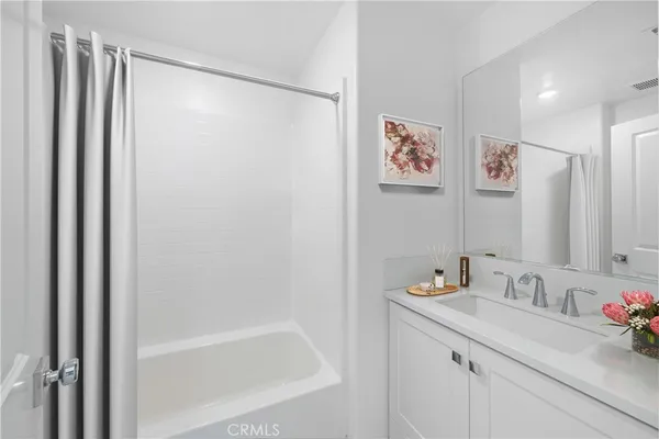 a bathroom with a granite countertop sink a mirror a shower and a bathtub