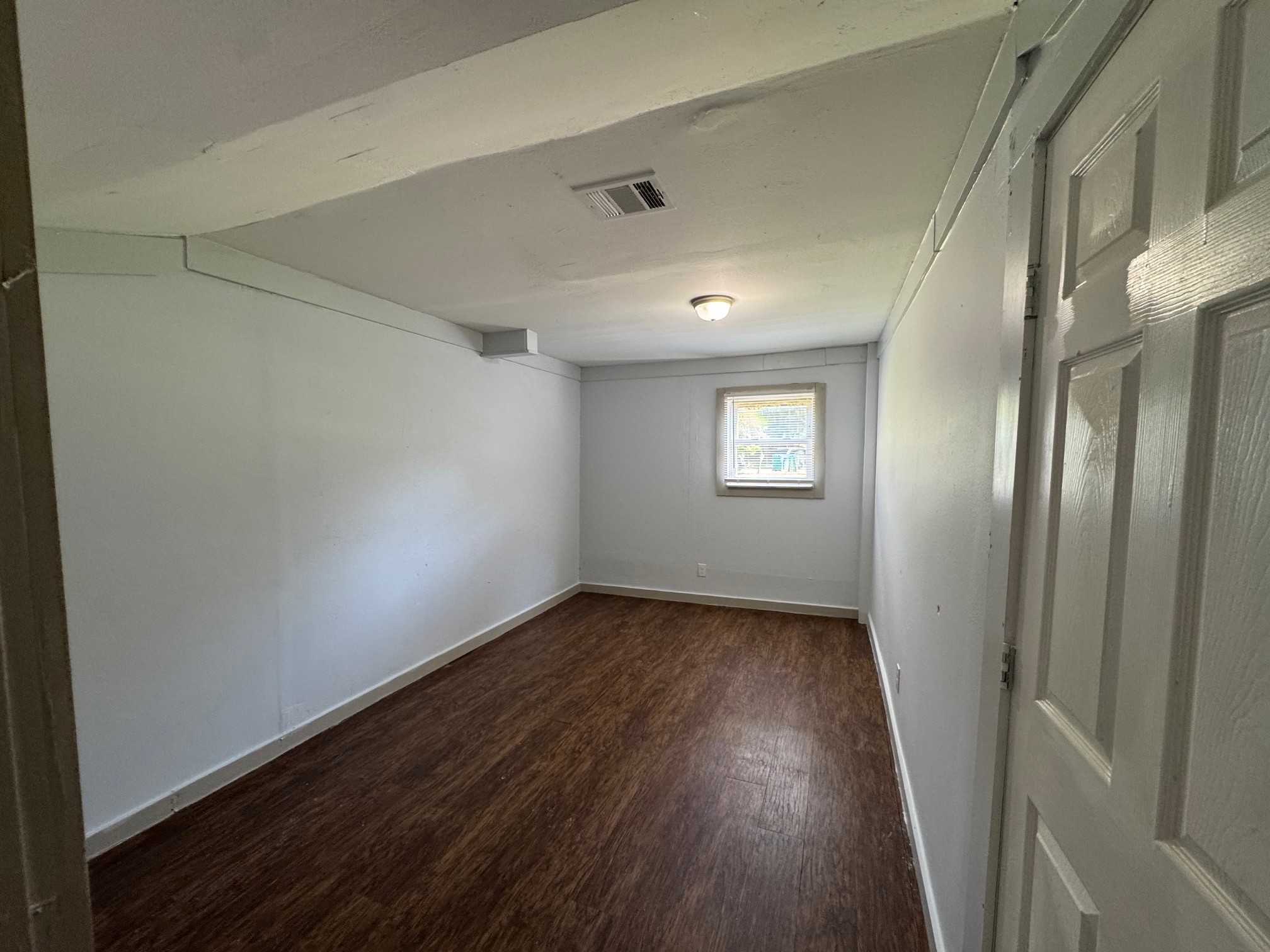 1104 Maple Street, Unit 2 La Marque, TX 77568 - Photo 6 of 16 a view of an empty room with wooden floor and a window