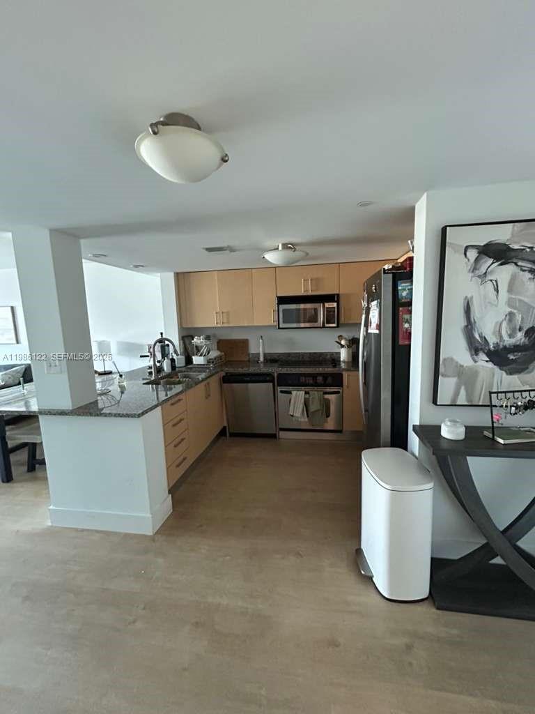 2101 Brickell Avenue, Unit 2102 Miami, FL 33129 - Photo 23 of 29 a kitchen with stainless steel appliances kitchen island granite countertop a stove and a sink