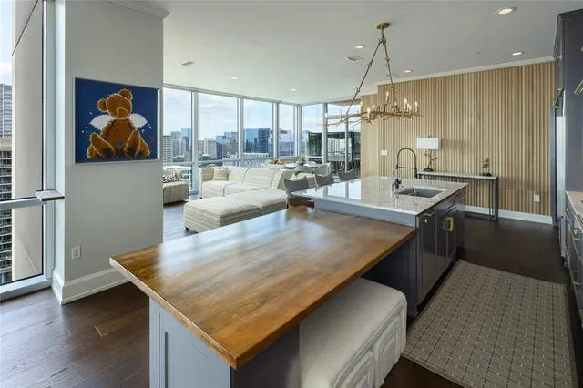 a living room with stainless steel appliances kitchen island granite countertop furniture and a wooden floor