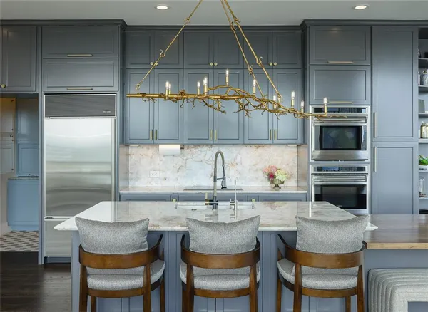 a kitchen with a table chairs refrigerator and cabinets