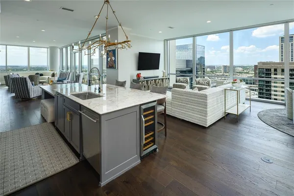 a large living room with couches a flat tv screen and a view of kitchen