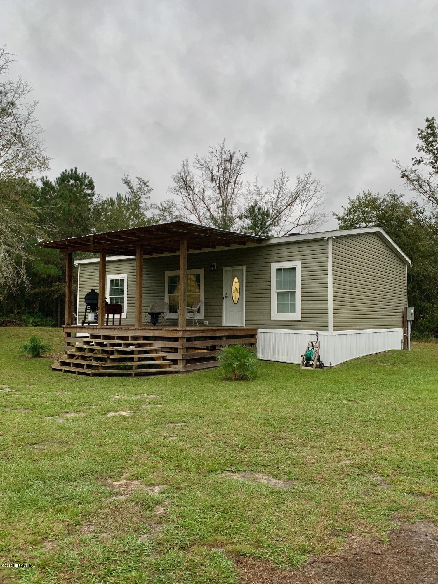 14227 Southwest 151st Avenue Brooker, FL 32622 - Photo 2 of 9 a backyard of a house with table and chairs