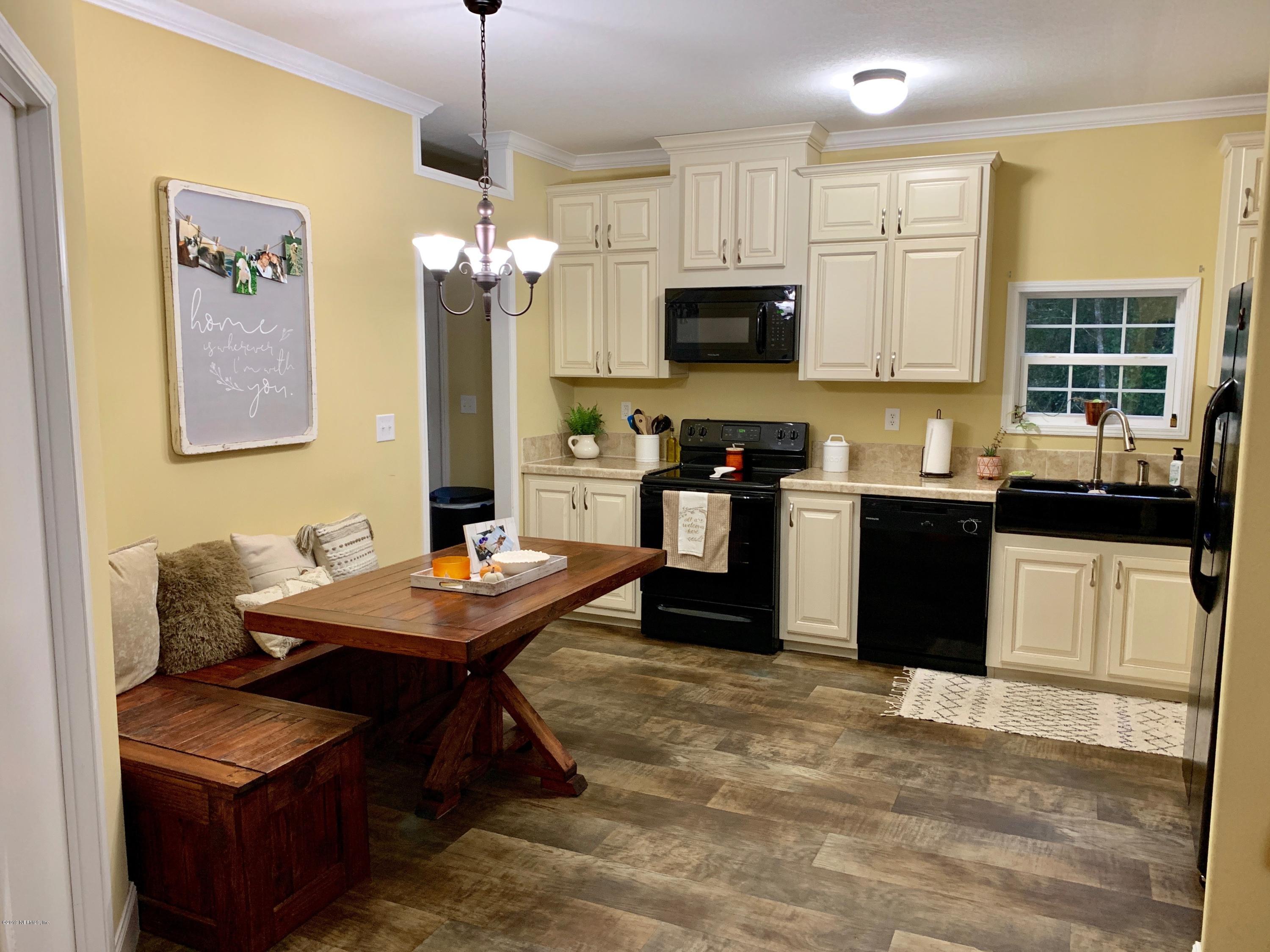 14227 Southwest 151st Avenue Brooker, FL 32622 - Photo 4 of 9 a kitchen with stainless steel appliances kitchen island granite countertop a sink dishwasher a stove and a refrigerator with wooden floor
