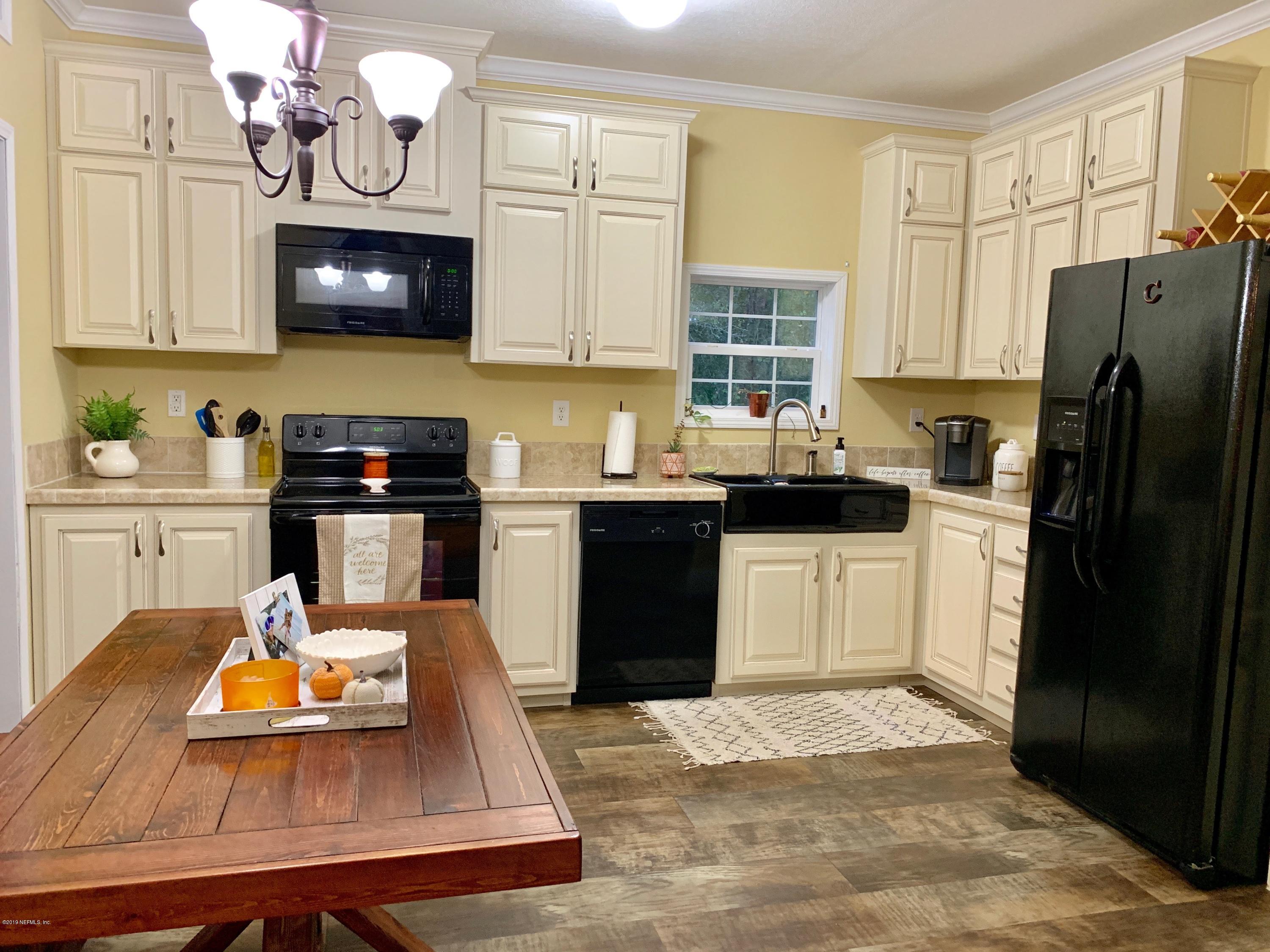 14227 Southwest 151st Avenue Brooker, FL 32622 - Photo 6 of 9 a kitchen with stainless steel appliances kitchen island granite countertop a refrigerator oven a sink dishwasher and a black appliances