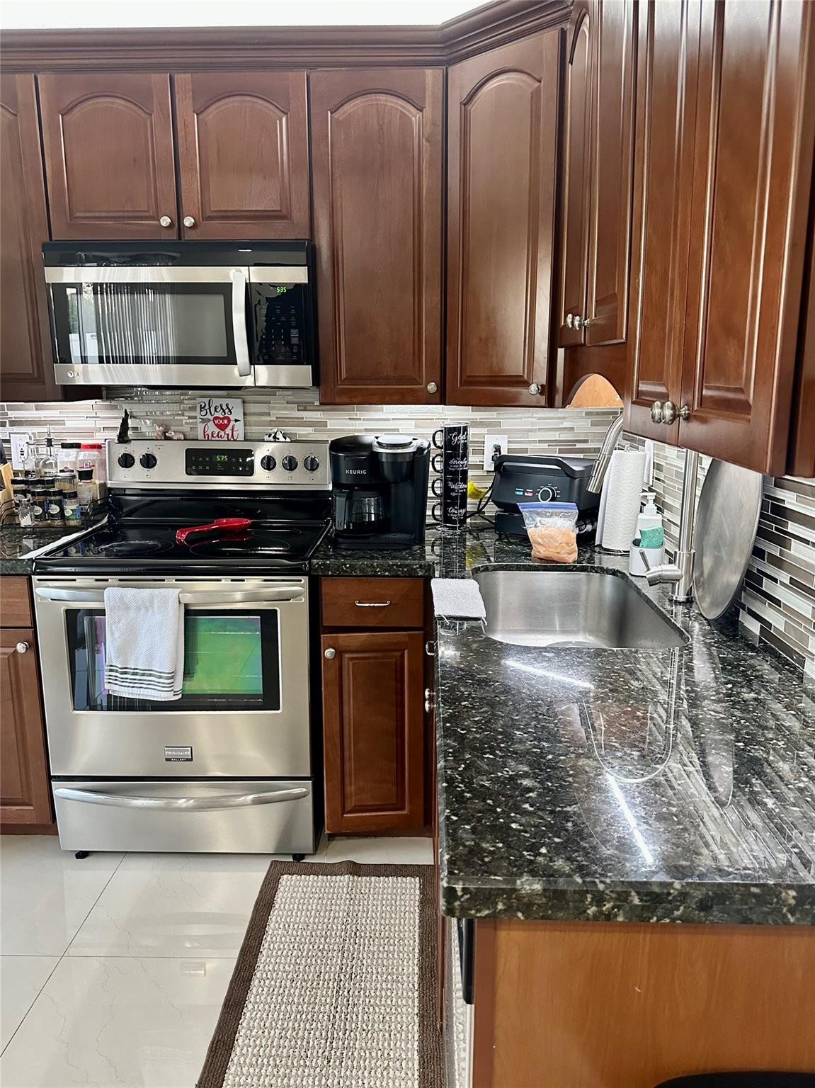 18814 Cloud Lake Circle Boca Raton, FL 33496 - Photo 13 of 19 a kitchen with stainless steel appliances granite countertop a stove a sink and a microwave