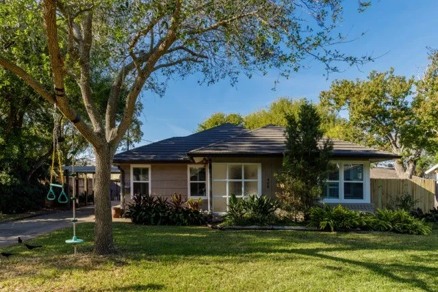a front view of a house with a yard tree and outdoor seating