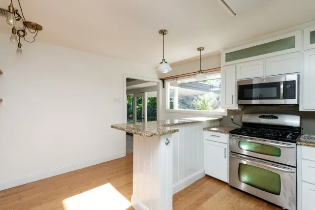 a kitchen with stainless steel appliances a stove a sink and a microwave