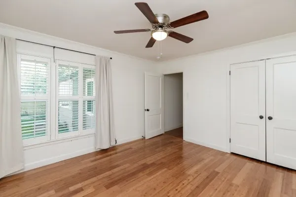 a view of a livingroom with wooden floor and a ceiling fan