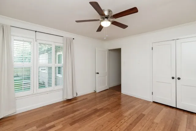 a view of a livingroom with wooden floor and a ceiling fan