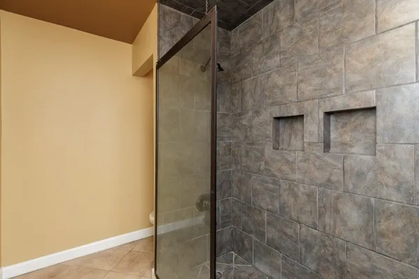 a view of an empty room with wooden floor and windows