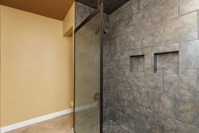 a view of an empty room with wooden floor and windows