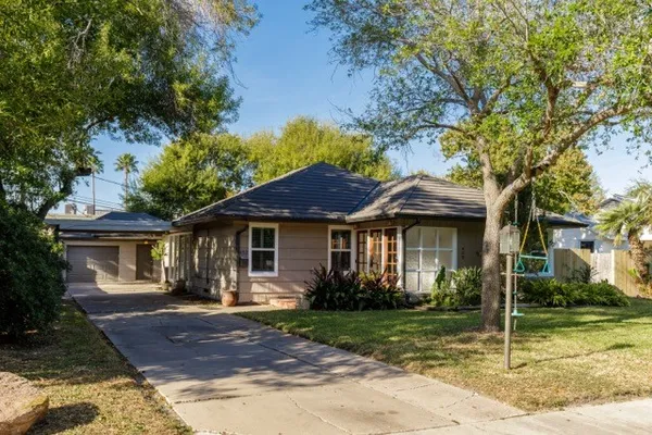 a view of a house with backyard and a tree