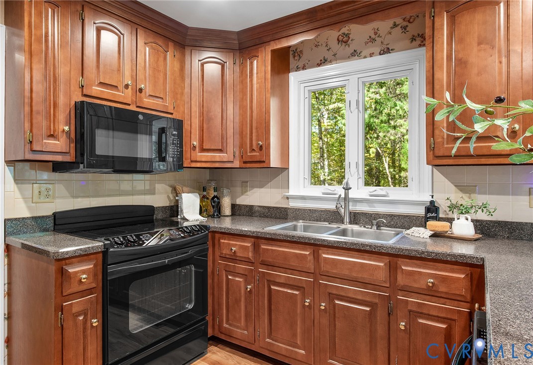 15010 Walnut Bend Road Midlothian, VA 23112 - Photo 11 of 35 a kitchen with granite countertop a stove a sink and a microwave