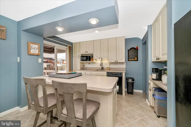 a kitchen with a dining table chairs refrigerator and cabinets