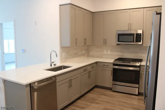 a kitchen with stainless steel appliances granite countertop a sink and a stove