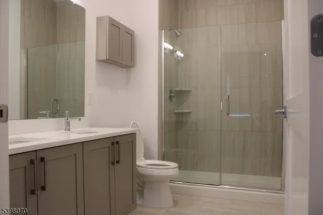 a bathroom with a granite countertop sink toilet and shower