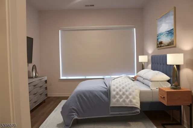 a bedroom with a bed and a potted plant on the dresser