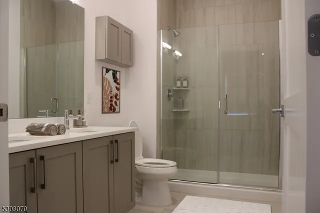 a bathroom with a double vanity sink toilet and shower