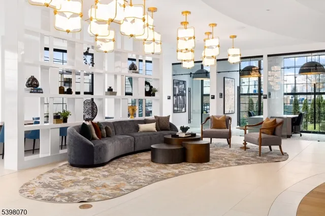 a living room with furniture large windows and wooden floor