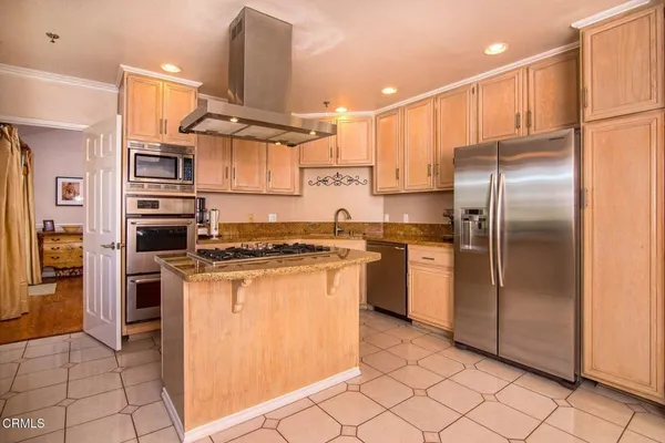 a kitchen with stainless steel appliances granite countertop a refrigerator a stove and a sink