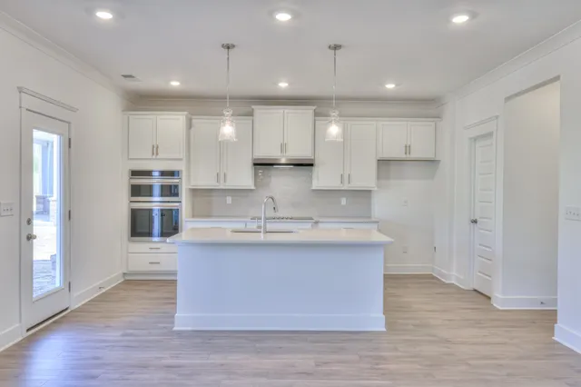 an empty room with wooden floor fireplace and windows