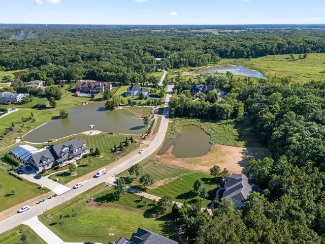 an aerial view of a house with a garden and lake view