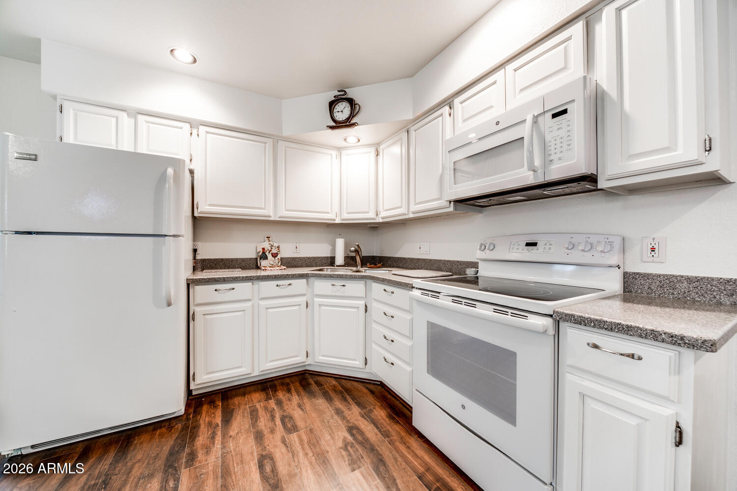 17200 West Bell Road, Unit 1260 Surprise, AZ 85374 - Photo 5 of 31 a kitchen with stainless steel appliances granite countertop a refrigerator sink and white cabinets